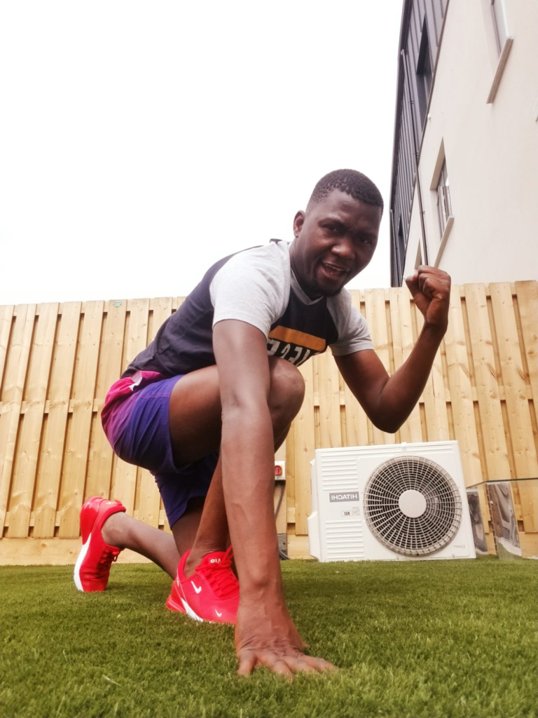 Albert is kneeling down in his back garden with his arm raised