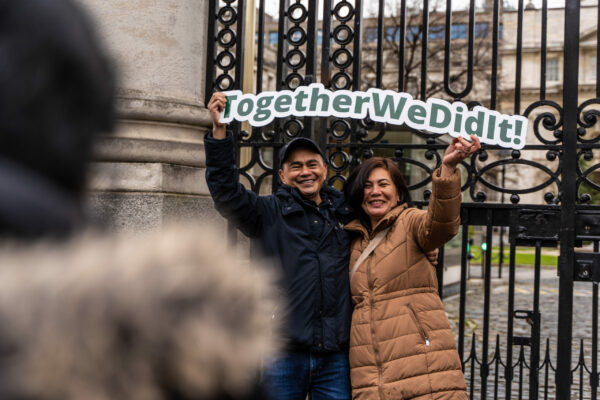 Members holding 'Together we did it' cut out