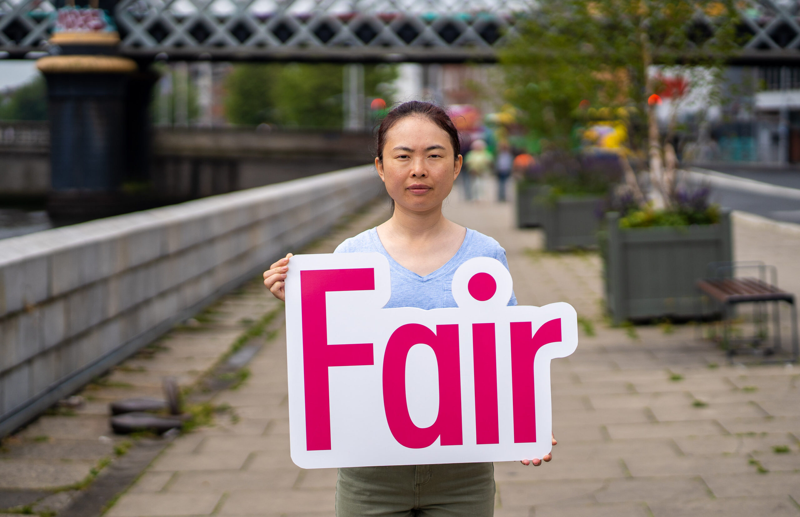 Campaigner holding cut-out reading 'Fair' for Fair Fees Campaign